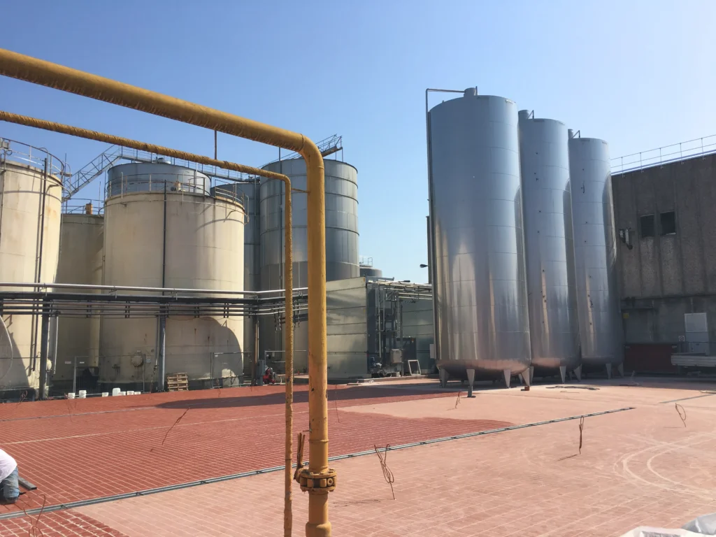 Impianto industriale con silos di stoccaggio e area produttiva in costruzione realizzato da Impref