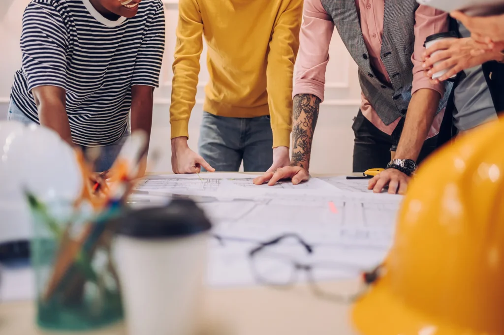 Team di progettazione al lavoro su planimetrie e disegni tecnici in ufficio