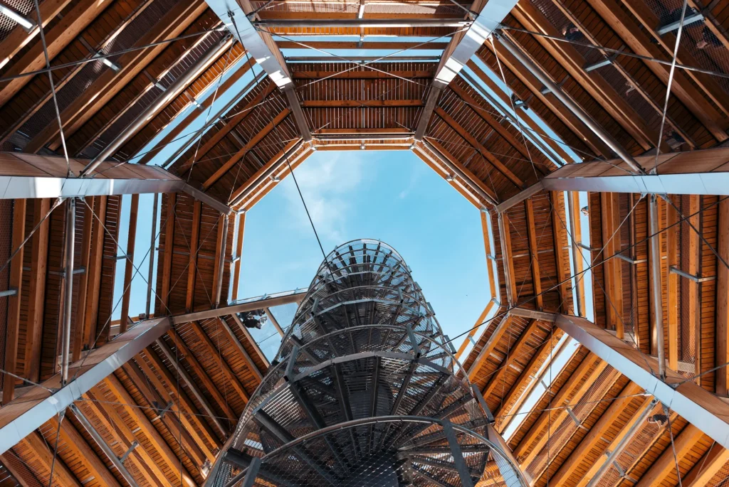 Struttura architettonica in legno e acciaio con scala a chiocciola vista dal basso