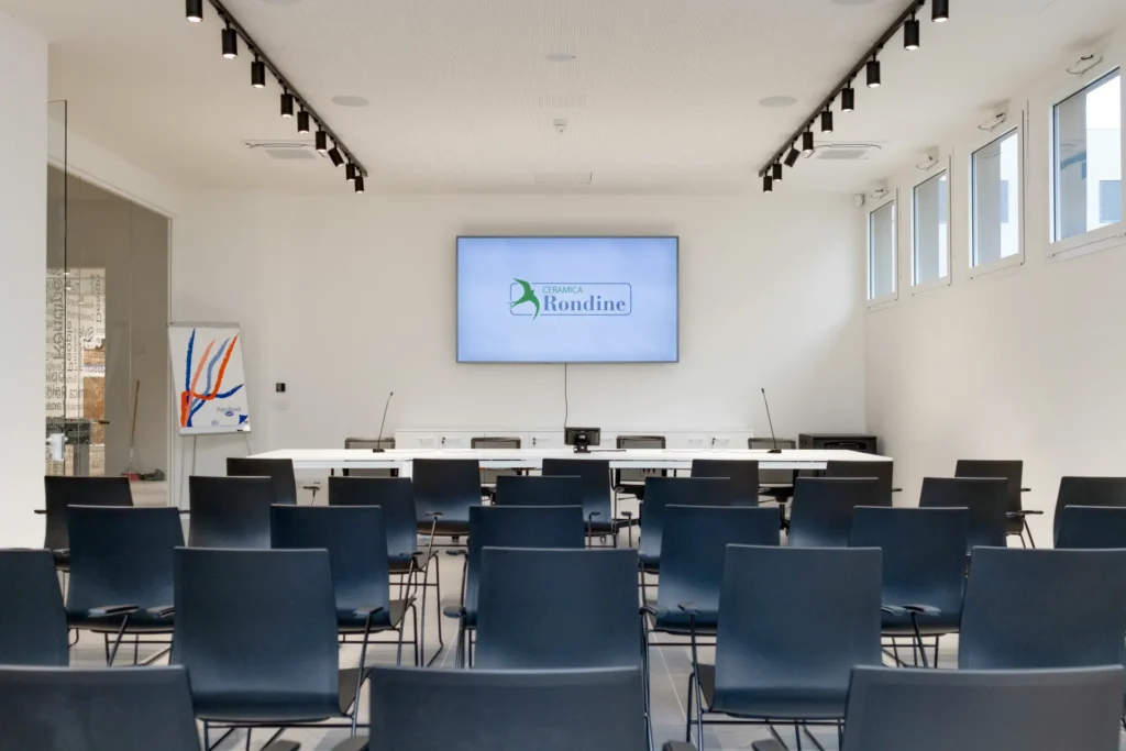 Sala conferenze moderna con sedute e schermo per presentazioni
