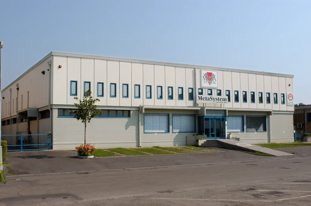 Edificio industriale bianco con ampie finestre e area esterna